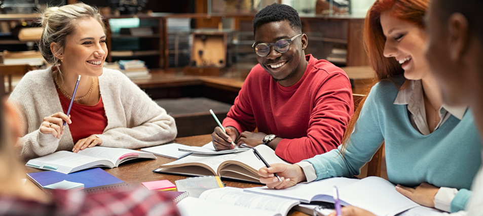 High school students sitting around table in library