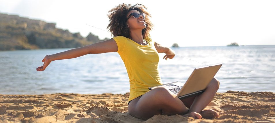 female student on laptop at the beach