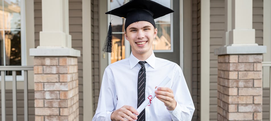 male student in graduation cap holding diploma