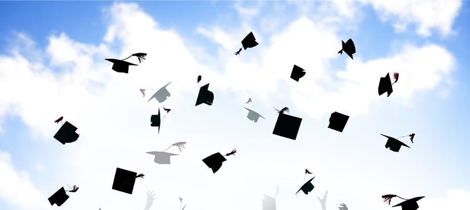 High school graduation caps tossed in the air