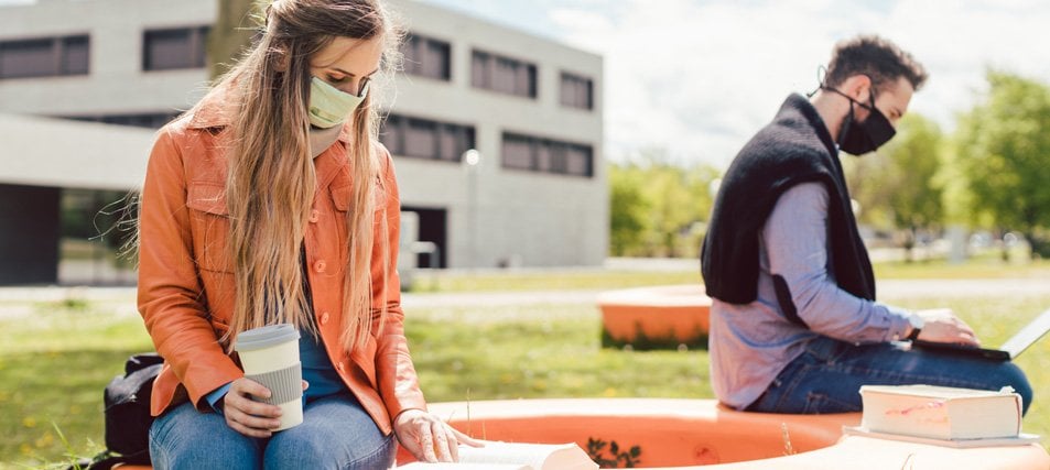 two students in mask studying on campus