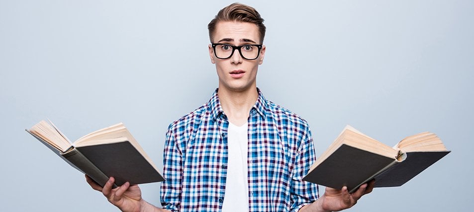 male student holding two books