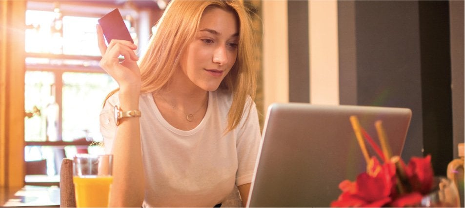 female student on laptop holding credit card