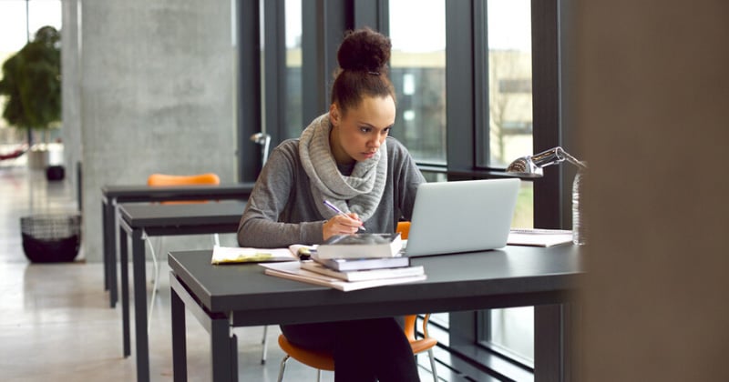 female student on laptop on campus