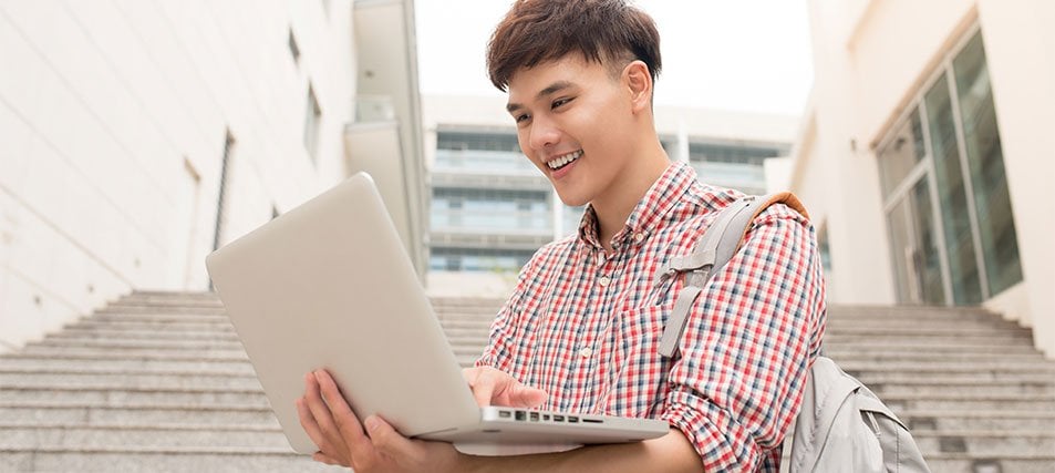 male student looking at laptop